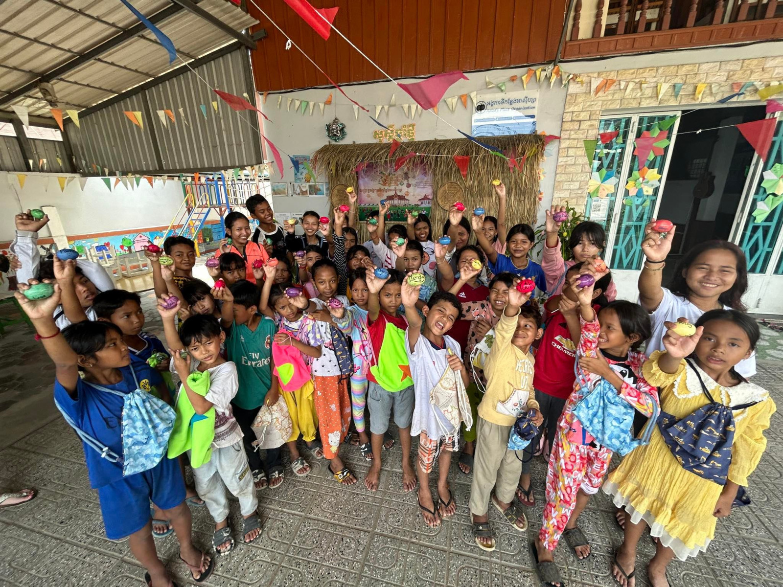 Kinder l&auml;cheln und halten bemalte Eier in die Kamera